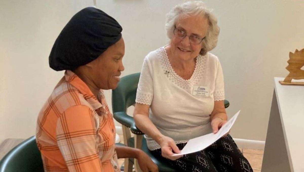 Sr. Judith Dohner helps a Haitian immigrant woman with paperwork.