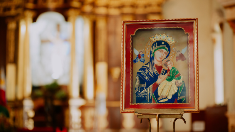 An icon of the Madonna and Child is on an easel inside a church