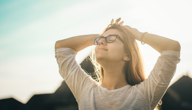 happy girl raises her face to the sun