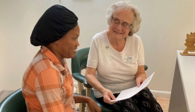 Sr. Judith Dohner helps a Haitian immigrant woman with paperwork.