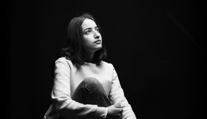 a woman sits alone with her thoughts